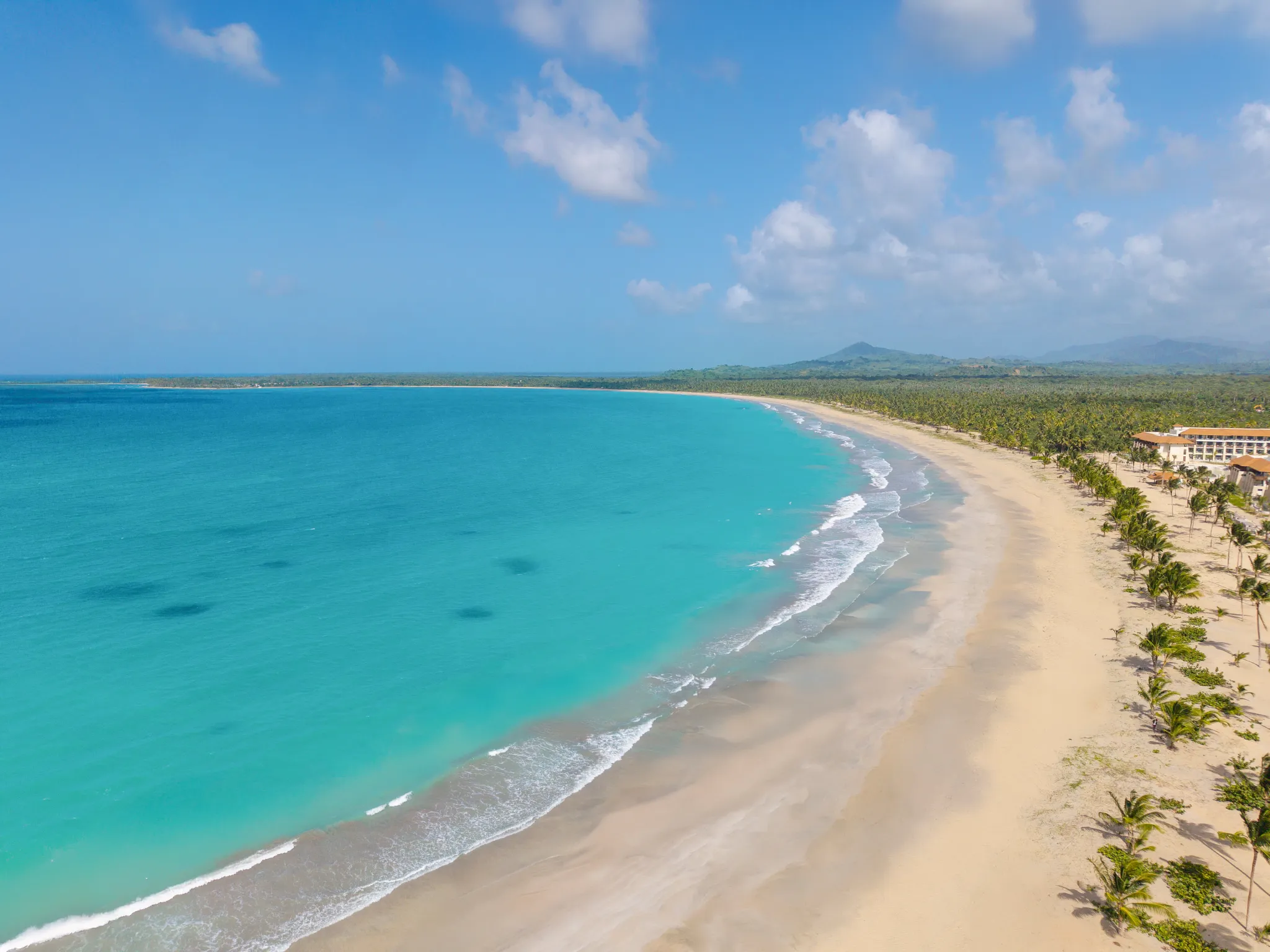 Aerial view of the turquoise shoreline and white-sand beach near Dreams Playa Esmeralda Resort & Spa in the Dominican Republic.