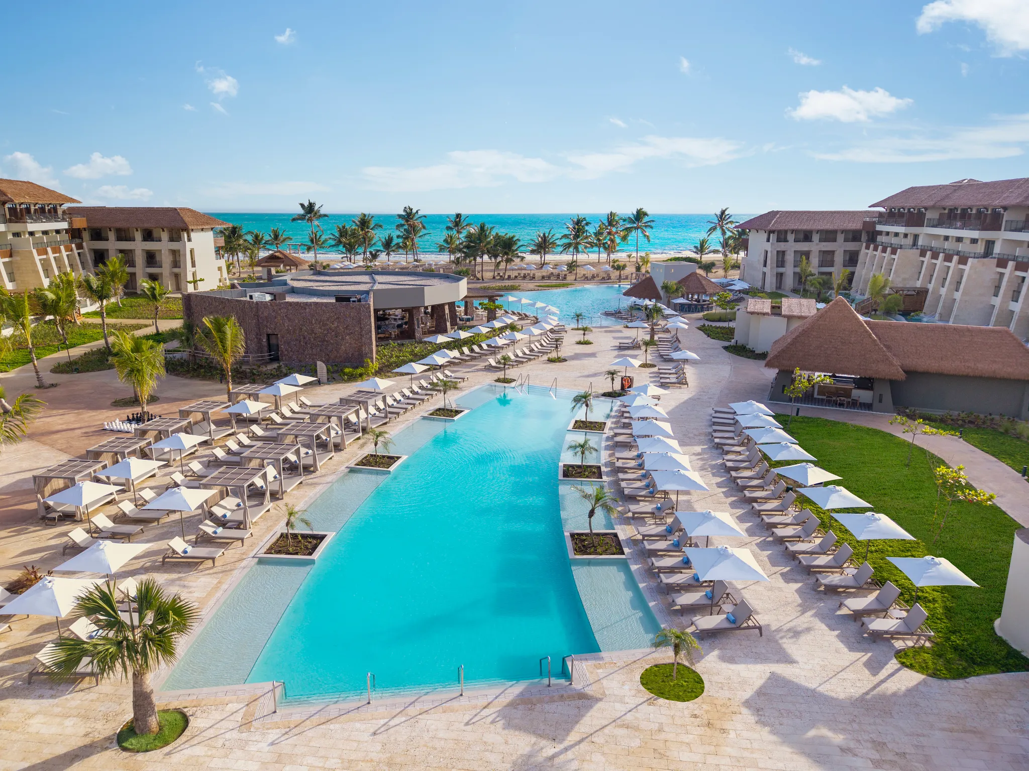 Aerial view of the main infinity-style pool and beachfront at Dreams Playa Esmeralda Resort & Spa.